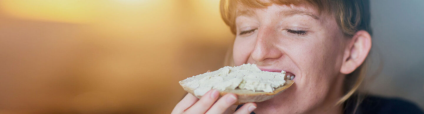 Woman eating a slice of bread with spread