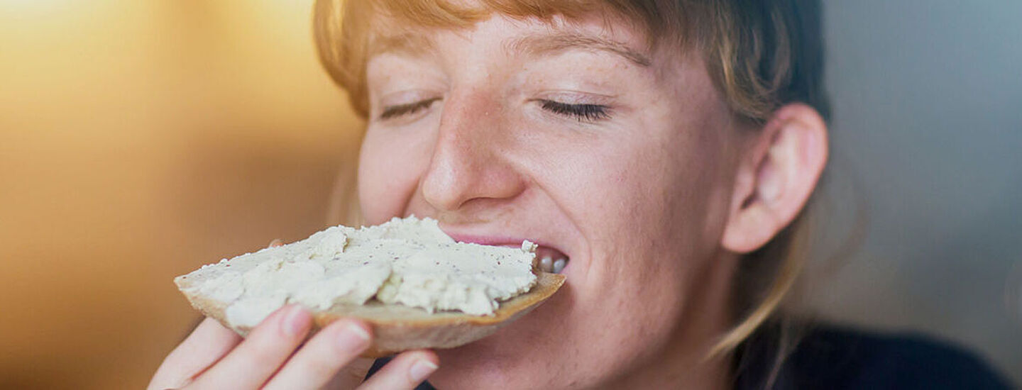 Woman eating a slice of bread with spread