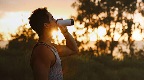men drinking energy drink at sunset