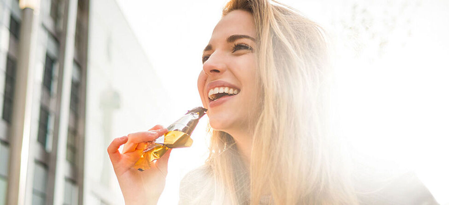 mujer comendo una barra de cereal