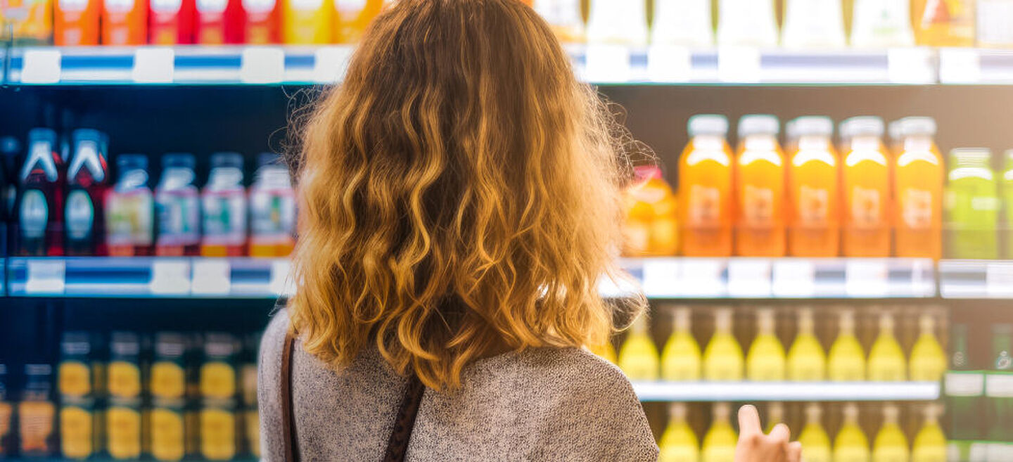 Woman stands in front of a supermarket shelf