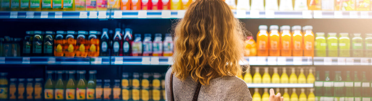 Woman stands in front of a supermarket shelf