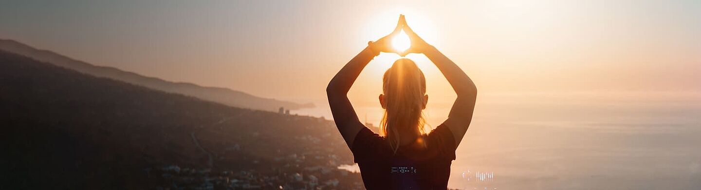 girl on the sunset with hands up