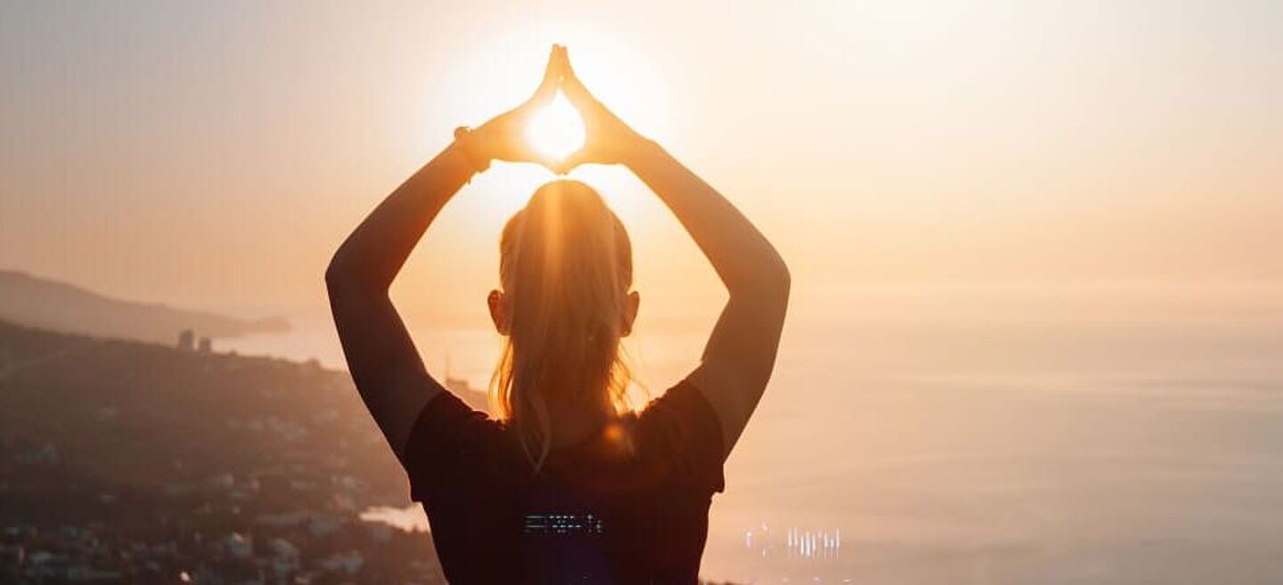 girl on the sunset with hands up