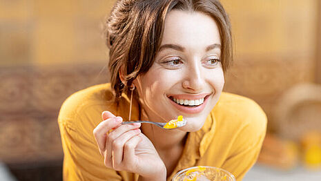 Uma mulher está a comer uma sobremesa de fruta