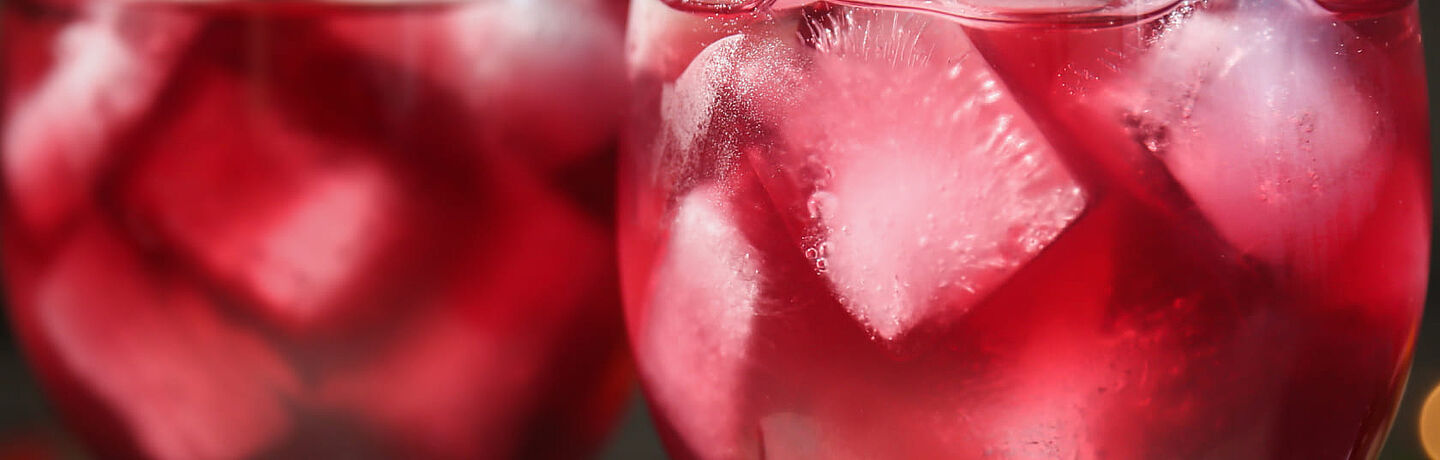 Bebida vermelha com cubos de gelo 