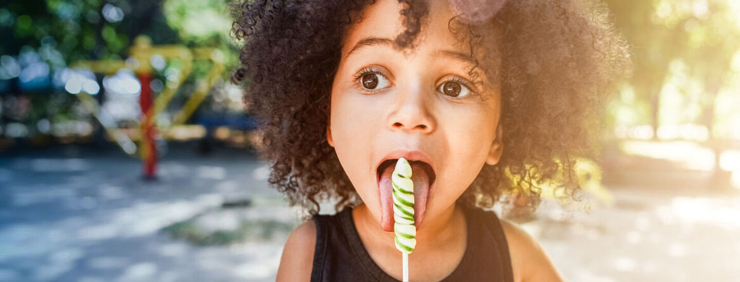 menina comendo pirulito