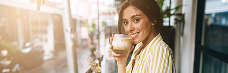 Frau mit Kaffee mit Schaum