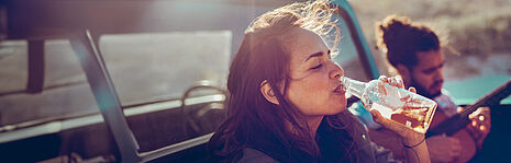 girl in a car drinking from a bottle