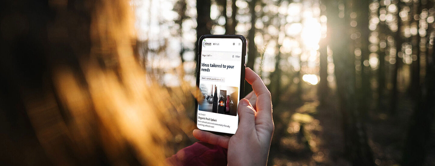 Woman holding a mobile phone in the middle of the forest