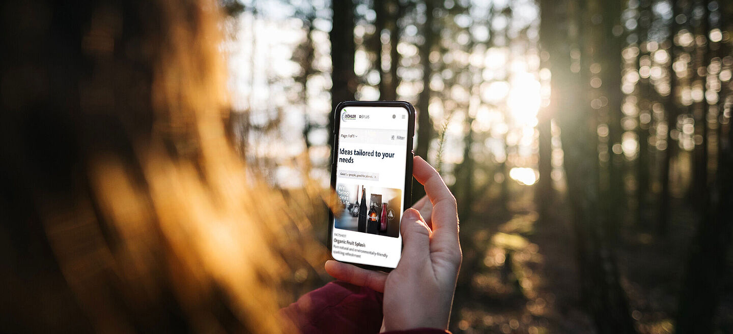 Woman holding a mobile phone in the middle of the forest