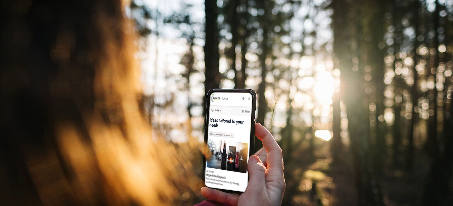 Frau, die im Wald das Handy hält