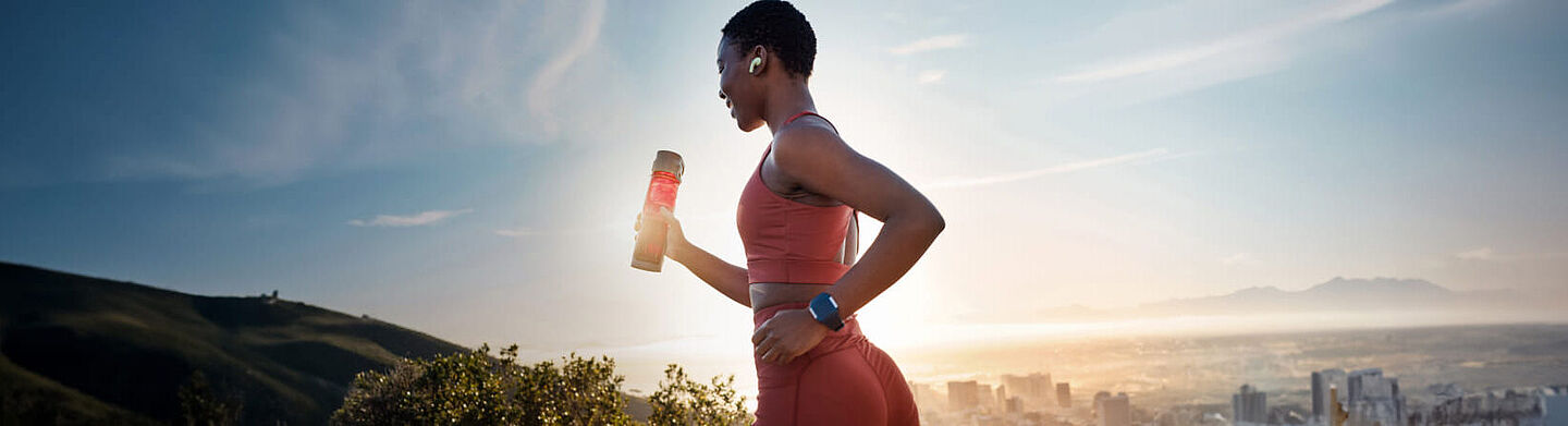 girl running with a sports drinks on the hand