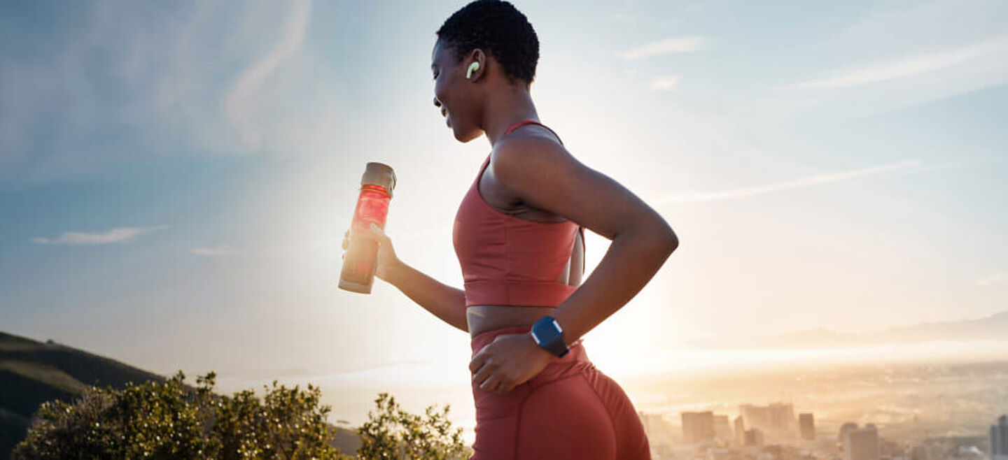 girl running with a sports drinks on the hand