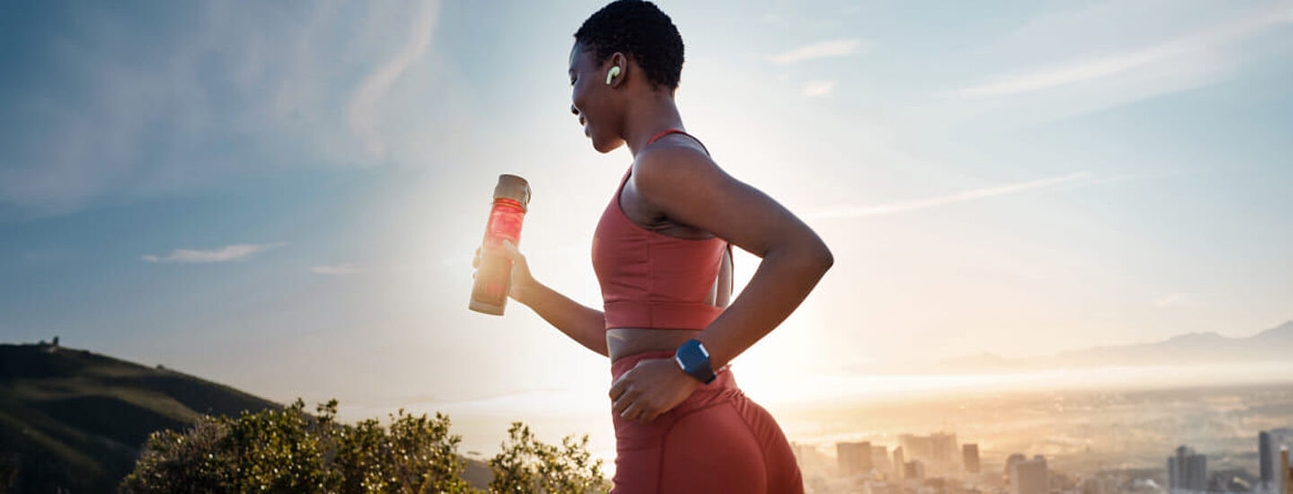 girl running with a sports drinks on the hand