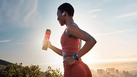 mulher a correr com uma bebida desportiva