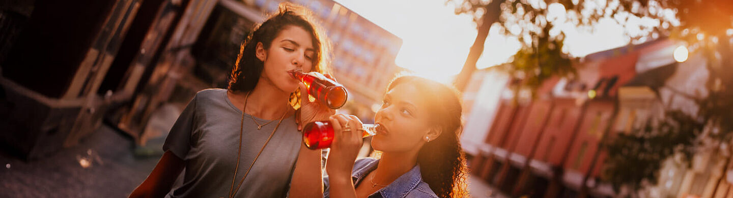 Amigos beben líquido rojo de una botella