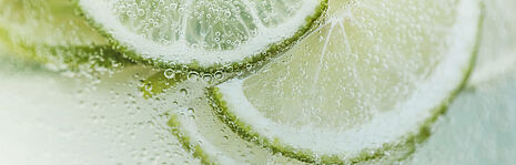 Sparkling lime slices in water, showcasing refreshing and vibrant natural freshness.