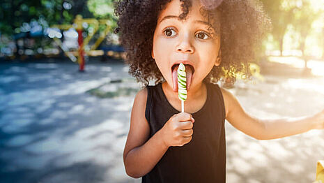 niña comiendo un pirulito