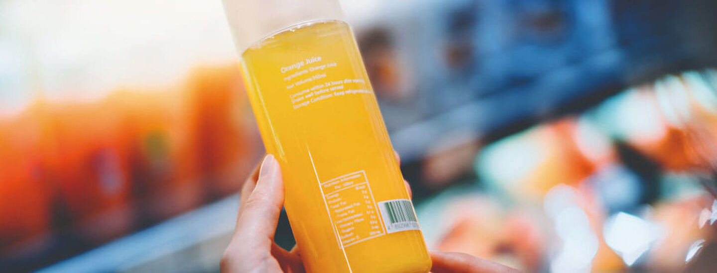 woman holding a bottle with orange liquid