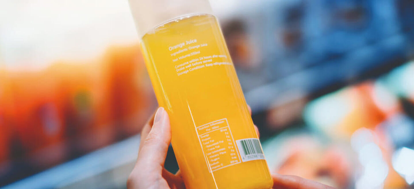 woman holding a bottle with orange liquid