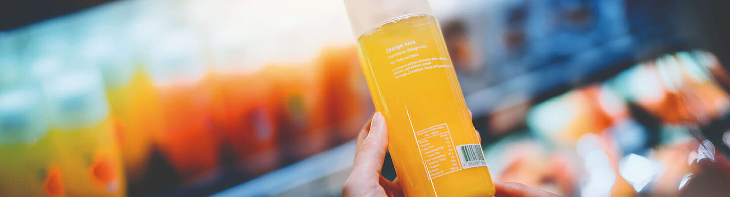 woman holding a bottle with orange liquid